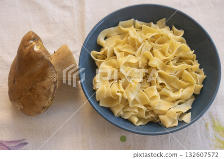 handmade egg pappardelle pasta in blue bowl with fresh porcini mushroom 132607572