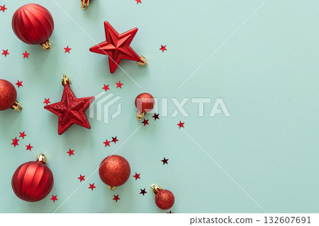 Red Christmas Ornaments and Confetti on Light Blue Background 132607691