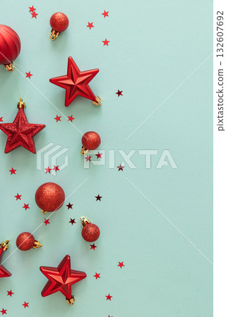 Red Christmas Ornaments and Confetti on Light Blue Background Red Christmas Ornaments and Confetti on Light Blue Background 132607692