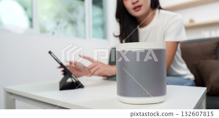 Technology. Woman interacting with smart speaker at home. Technology. Woman interacting with smart speaker at home. 132607815