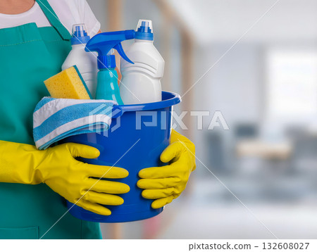 Cleaning worker holding bucket with detergents and sponge in office, yellow gloves, professional janitorial service 132608027