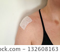 Injury recovery concept showing female shoulder with medical patch on deltoid muscle after training or inflammation, physical therapy background 132608163