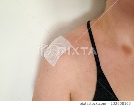 Injury recovery concept showing female shoulder with medical patch on deltoid muscle after training or inflammation, physical therapy background Injury recovery concept showing female shoulder with medical patch on deltoid muscle after training or inflammation, physical therapy background 132608163