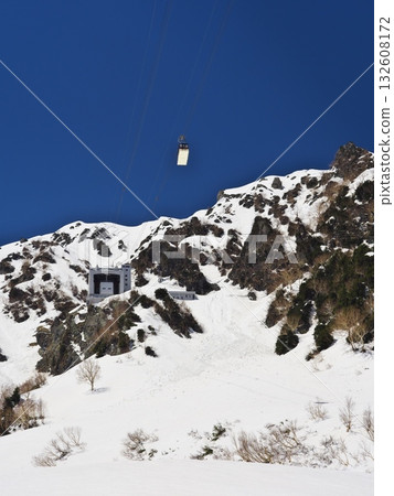 Snow still remaining on the Tateyama Kurobe Alpine Route, overlooking the Tateyama Ropeway gondola and Daikanbo Station from Tambo-daira 132608172