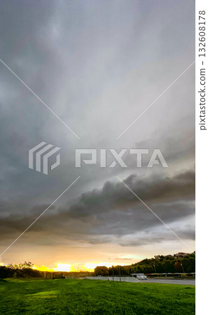A Stunning and Majestic Sunset Arises Behind Dark Stormy Clouds Over a Lush, Colorful Landscape A Stunning and Majestic Sunset Arises Behind Dark Stormy Clouds Over a Lush, Colorful Landscape 132608178