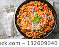 Delicious Chicago spaghetti with spicy tomato sauce, minced meat, parmesan, green pepper and herbs close-up in a plate. Horizontal top view 132609040