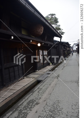 日本岐阜縣高山市的古老街景。一家用杉木球裝飾的清酒店和一棟充滿歷史氣息的老房子。高山春季祭典期間的清晨景象。 日本岐阜縣高山市的古老街景。一家用杉木球裝飾的清酒店和一棟充滿歷史氣息的老房子。高山春季祭典期間的清晨景象。 132609272