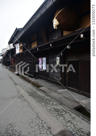 日本岐阜縣高山市的古老街景。一家用杉木球裝飾的清酒店和一棟充滿歷史氣息的老房子。高山春季祭典期間的清晨景象。 132609273