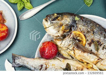 Oven-roasted fish served with plums. Oven-roasted fish served with plums. 132609561