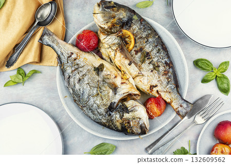 Oven-roasted fish served with plums. Oven-roasted fish served with plums. 132609562