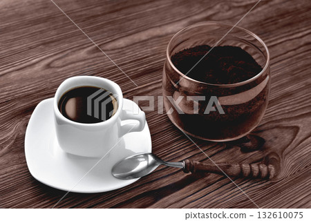 coffee in a cup on a stone stand ground coffee in a glass jar vintage coffee spoon, wooden natural background 132610075