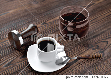 coffee in a cup ground coffee in a glass jar, temper wooden natural background 132610077