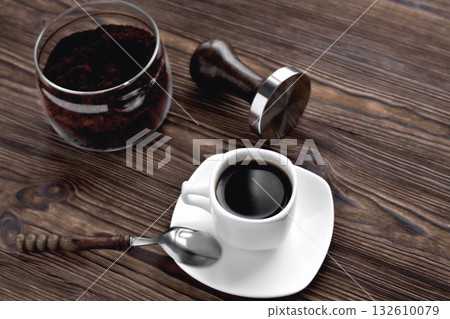 coffee in a cup ground coffee in a glass jar, temper wooden natural background 132610079