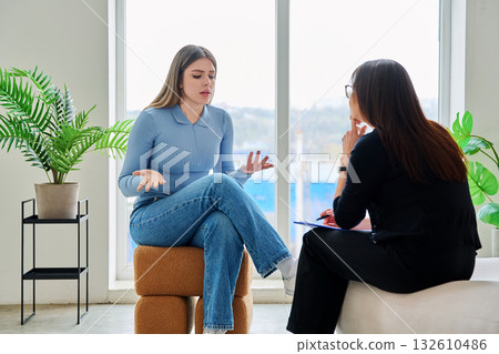 Young woman in a therapy session talking with a psychotherapist Young woman in a therapy session talking with a psychotherapist 132610486