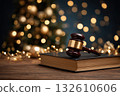 Wooden gavel rests on a book near Christmas tree 132610606
