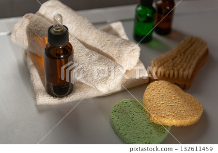Cosmetic serum glass dropper bottles in bathroom with towel on sunshine 132611459