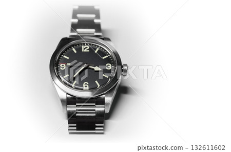 A watch with black dial on steel case and bracelet with satin finish lays on white 132611602