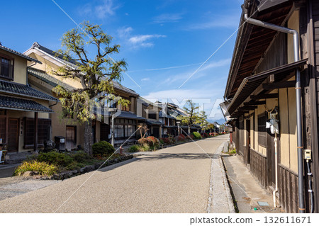 Under the blue sky, Unnojuku is lined with old wooden houses with lattice doors along a wide gravel road. 132611671