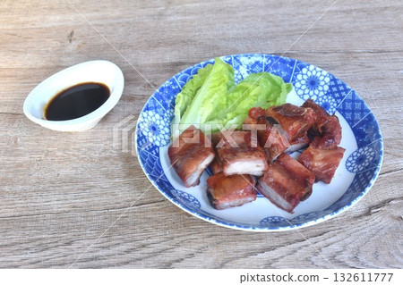 fried crispy pork bone or rib with baby cos lettuce on plate dipping black sweet sauce cup 132611777