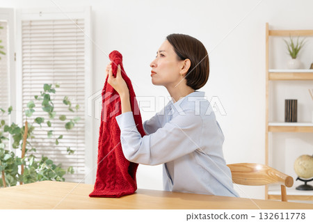 A woman who is troubled by the smell of her clothes 132611778