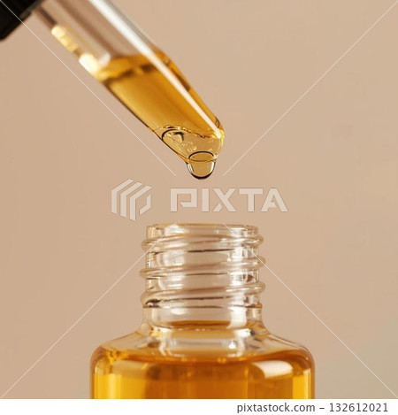 Jojoba oil dripping from a dropper Jojoba oil dripping from a dropper 132612021