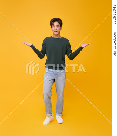 Copy space choice concept cheerful Asian man presenting two options with open palms on yellow background for ad banner, product mockup, decision making, and marketing design. 132612048