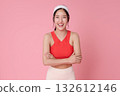 Fitness woman on pink background in red sports top smiling with arms crossed for wellness active lifestyle athleisure advertising and healthy gym marketing with copy space 132612146