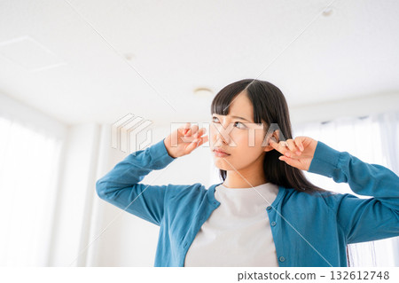 A young woman who plugs an ear A young woman who plugs an ear 132612748