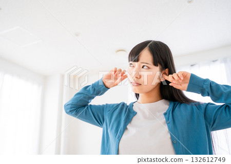A young woman who plugs an ear A young woman who plugs an ear 132612749