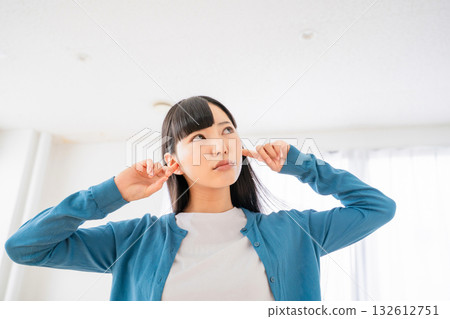 A young woman who plugs an ear 132612751