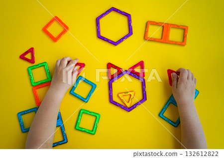 Kid playing with geometric forms colorful constructor. 132612822