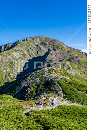 Mt. Ainotake seen from the hiking trail to Mt. Nishinotori. Climbing Mt. Ainotake and Mt. Notori of the Shiramine Sanzan mountains in the Southern Alps. Mt. Ainotake seen from the hiking trail to Mt. Nishinotori. Climbing Mt. Ainotake and Mt. Notori of the Shiramine Sanzan mountains in the Southern Alps. 132612895