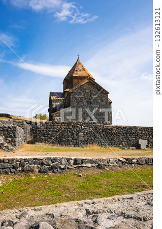 A large stone building with a steeple sits on a hill A large stone building with a steeple sits on a hill 132613121