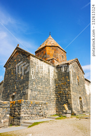 A large stone building with a steeple and a cross on top A large stone building with a steeple and a cross on top 132613124