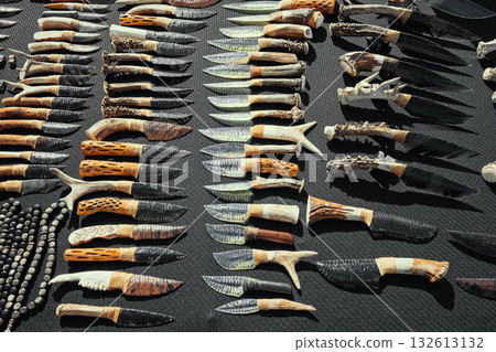 A table full of knives with antlers on them A table full of knives with antlers on them 132613132