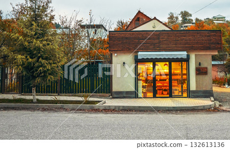 A small building with a green fence and a brown roof 132613136