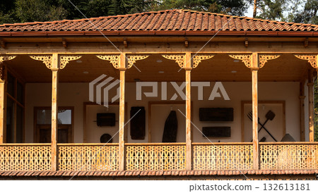 A balcony with a wooden railing and a roof A balcony with a wooden railing and a roof 132613181