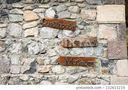 Three signs on a stone wall, one of which says "restaurant" Three signs on a stone wall, one of which says "restaurant" 132613210