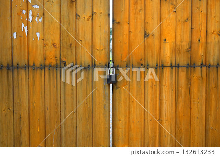 A wooden gate with a lock on it 132613233