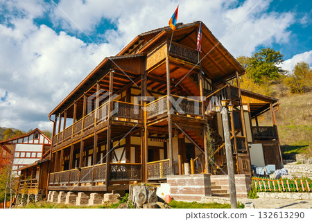 A large wooden house with a balcony and a flag on top A large wooden house with a balcony and a flag on top 132613290