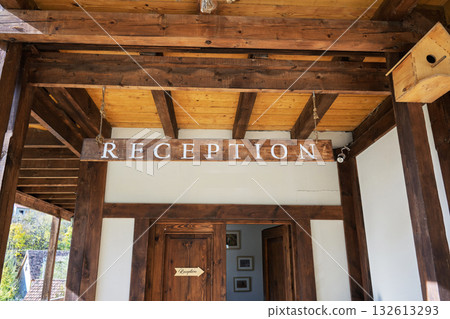 A wooden sign hanging from the ceiling that says "reception." 132613293