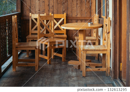 A wooden patio set with a round table and six wooden chairs 132613295