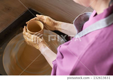 A woman's hands shaping a pottery using a potter's wheel 132613631