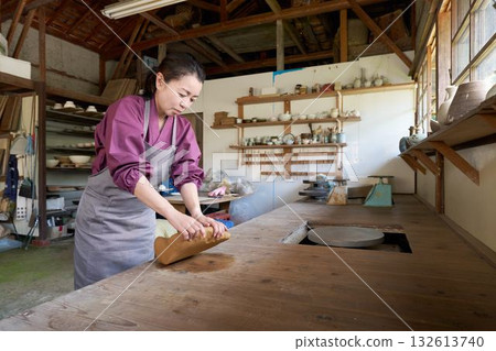 Woman kneading clay in a pottery studio Woman kneading clay in a pottery studio 132613740