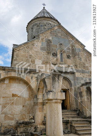 A large stone building with a steeple and a cross on top 132613927