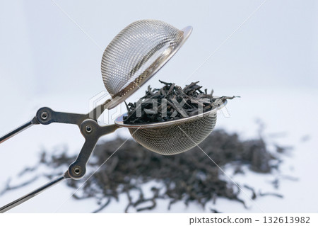 Loose Leaf Black Tea in a Metal Tea Infuser on White Background Loose Leaf Black Tea in a Metal Tea Infuser on White Background 132613982
