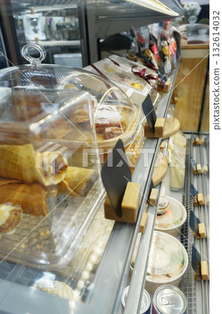 Display of assorted pastries and desserts in a modern cafe setting 132614032