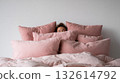 Cozy moments in a soft pink bed 132614792