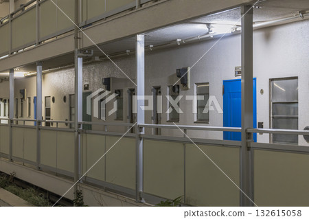 Night view of a housing complex corridor and a blue door Night view of a housing complex corridor and a blue door 132615058