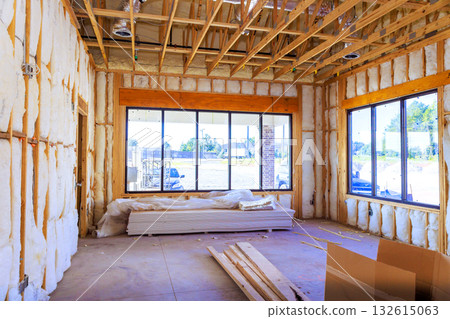 Inside building under construction exposed framing, insulation, unfinished floors, tools, materials. Inside building under construction exposed framing, insulation, unfinished floors, tools, materials. 132615063